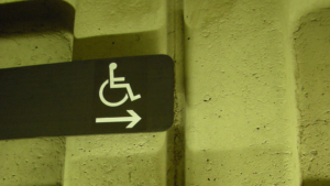 Señal de persona en silla de ruedas y una flecha indicando dirección a la derecha