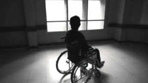 Hombre en silla de ruedas pegado a un ventanal
